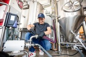 MSU Denver’s Elliot Knight cleans the fermentor in the Brewing Science and Technology class on Oct. 9, 2024, inside the School of Hospitality building.